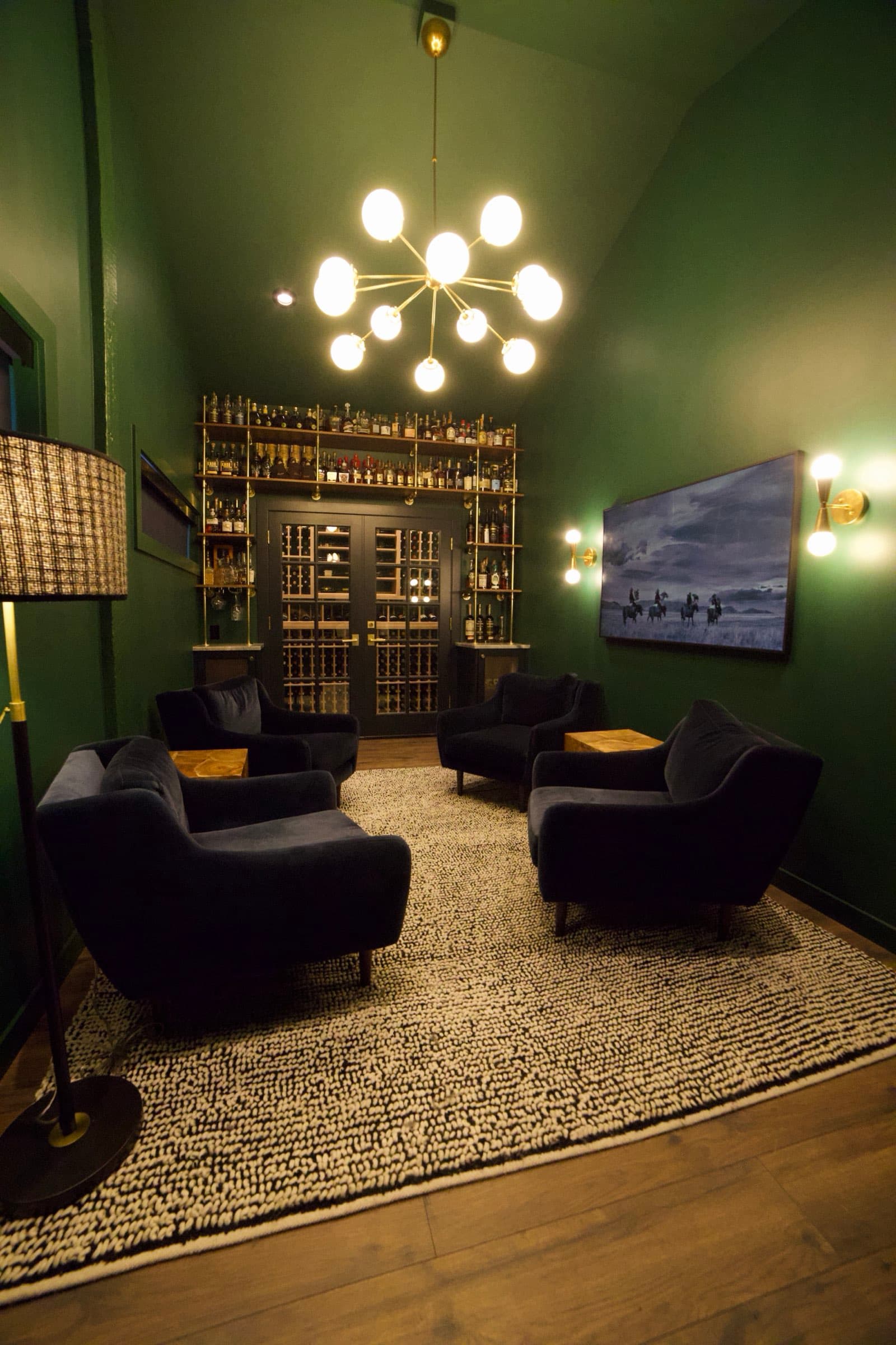 Full room view — velvet chairs, chandelier, and warm lighting