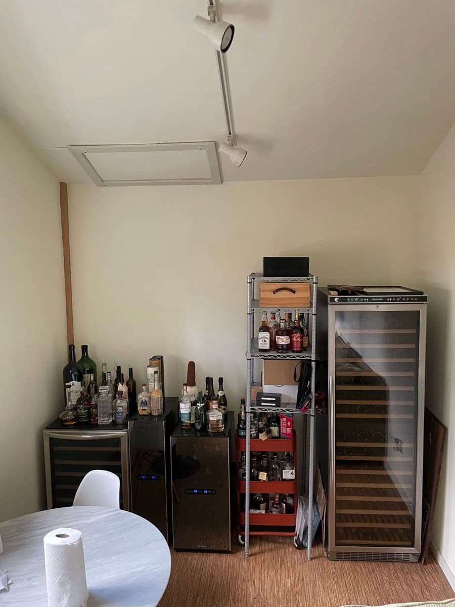 The original room — wine fridges and metal racks against the back wall