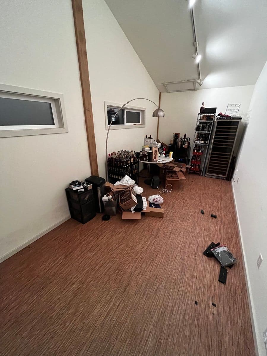 The original garage room — wine fridges and clutter against the back wall