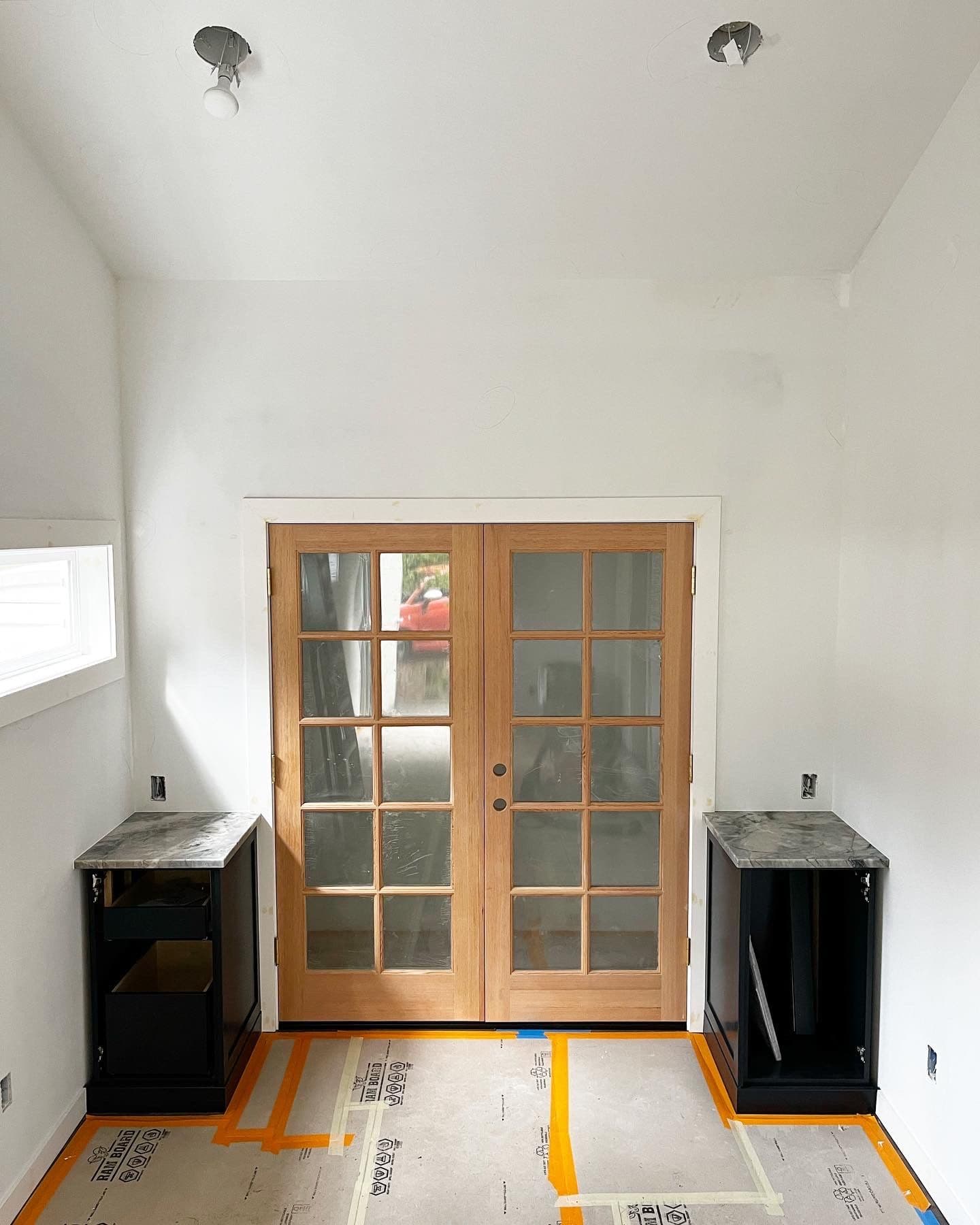 Finished French doors with marble-topped cabinets flanking them