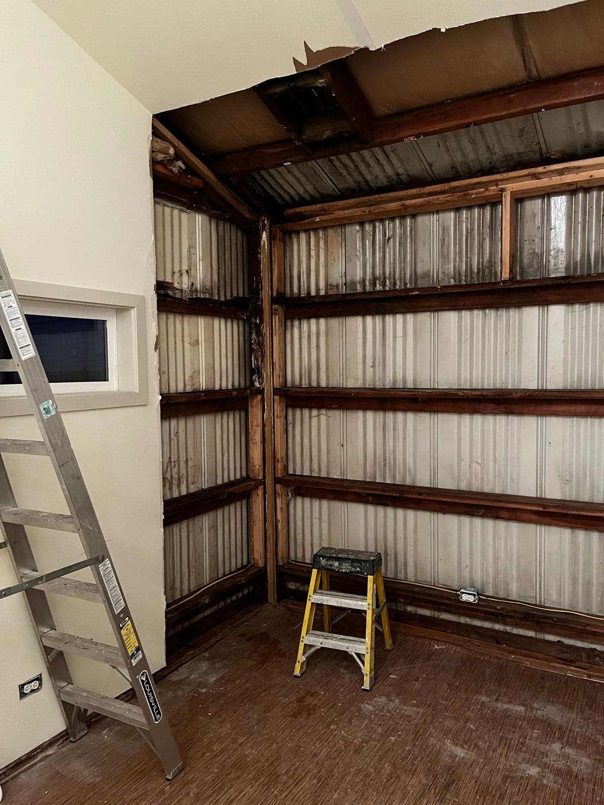 Ceiling torn open revealing corrugated metal and green paint swatches