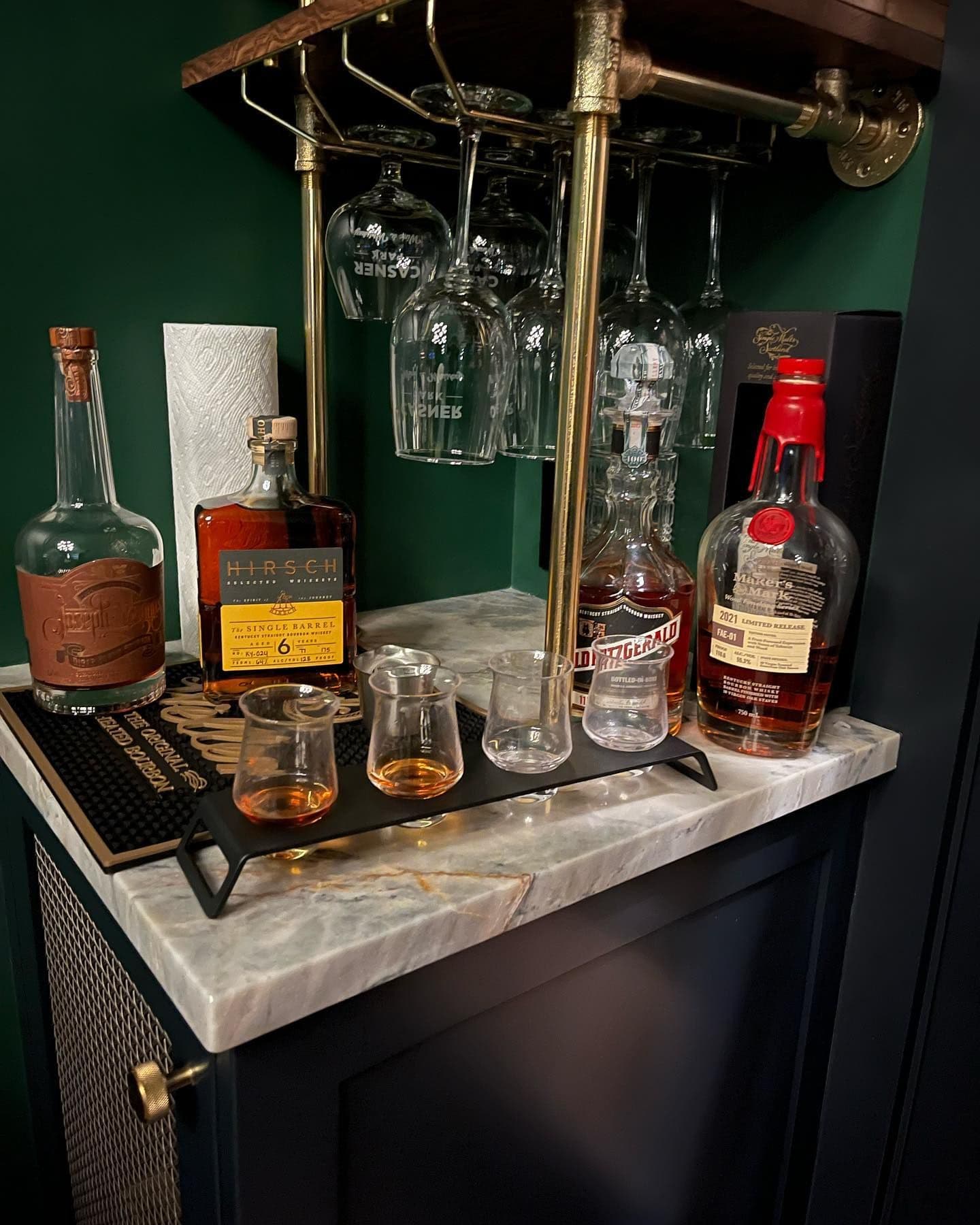 Brass pipe glass rack with hanging Glencairns above the marble counter