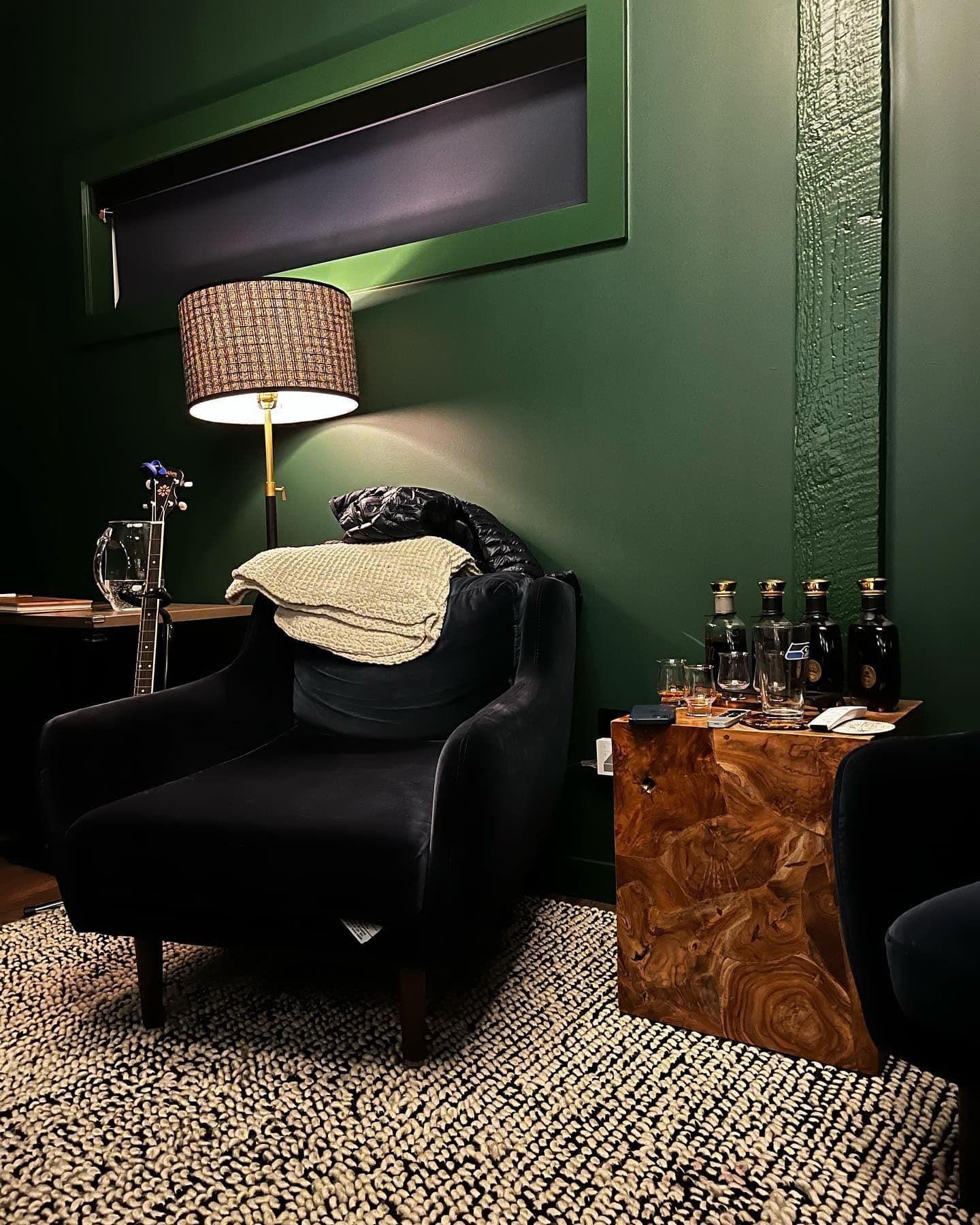 Velvet chair with throw blanket, floor lamp, and burl wood side table