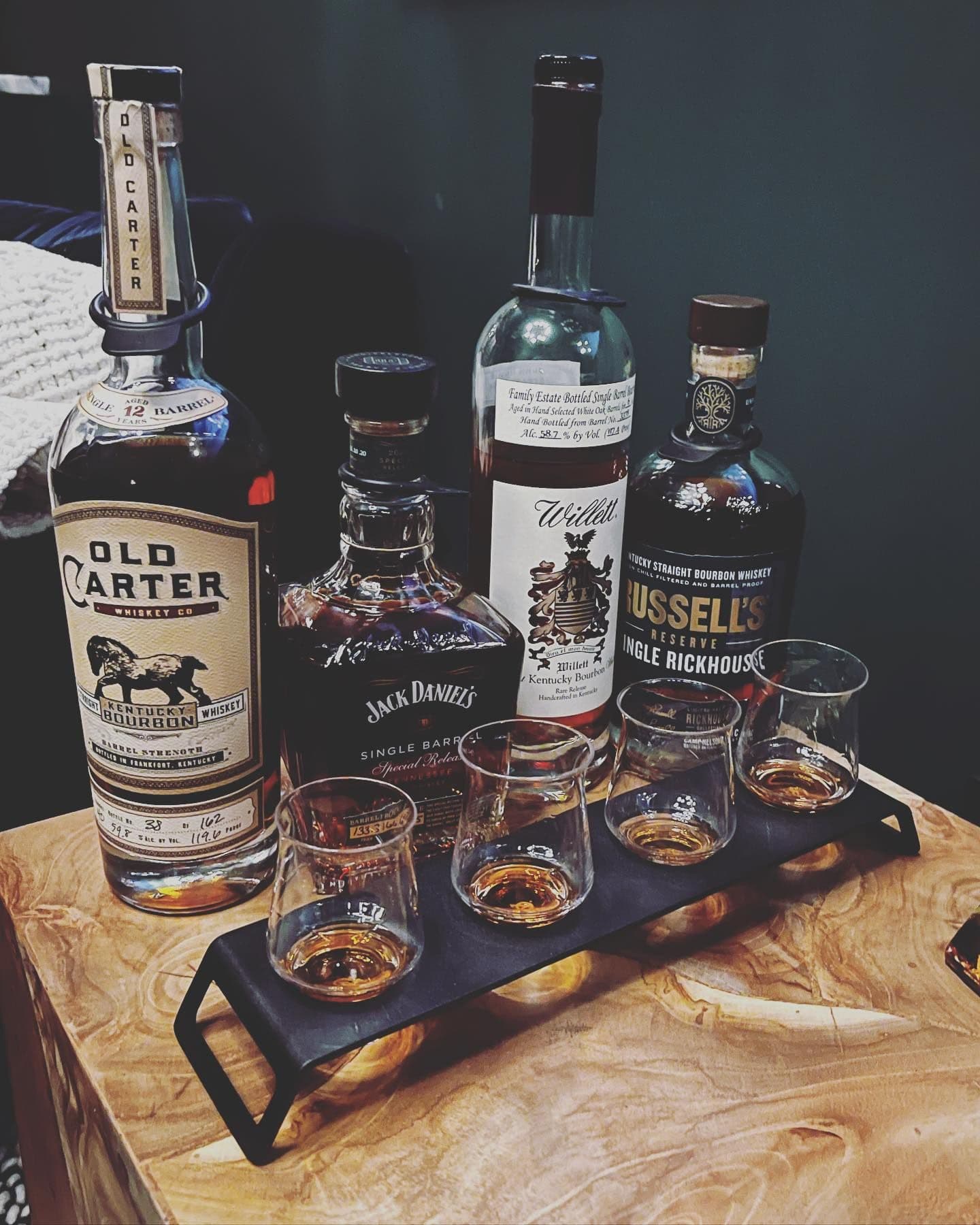 Old Carter, Jack Daniel's, and Willett flight on the burl wood table