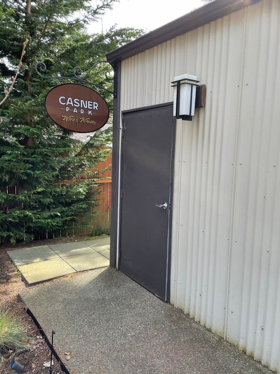 The finished exterior — sign hanging by the entrance with lantern light