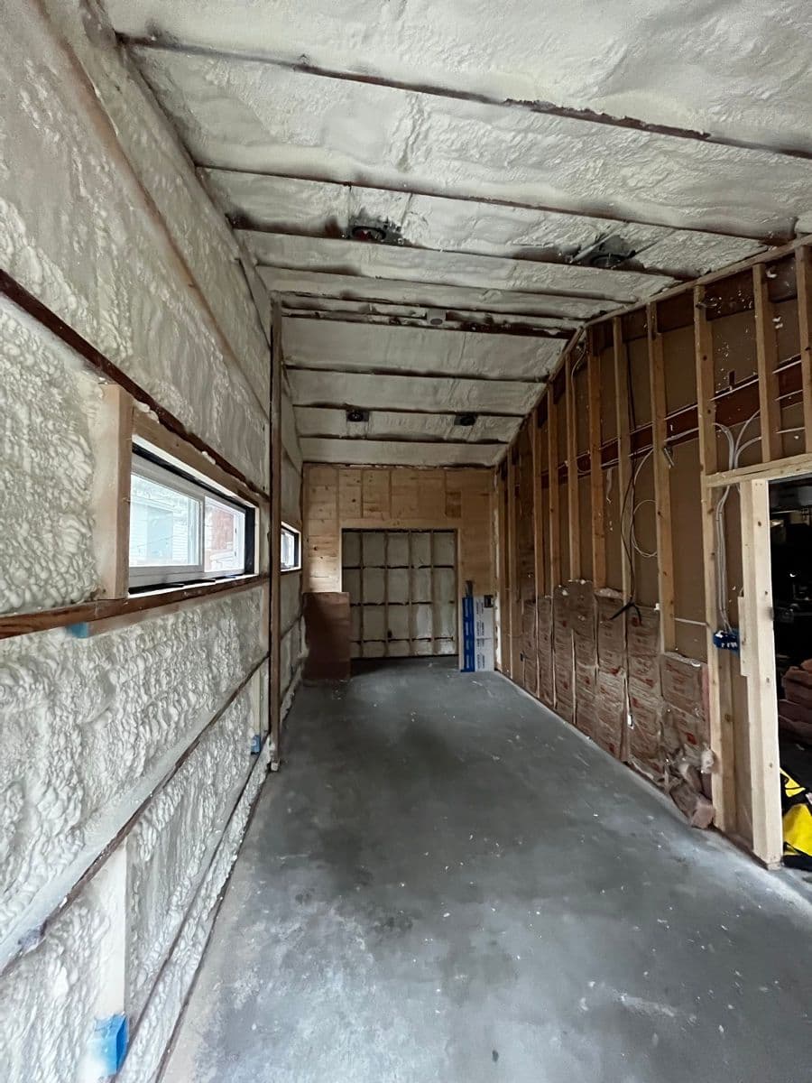 Wine cellar room insulated — spray foam between studs with window visible