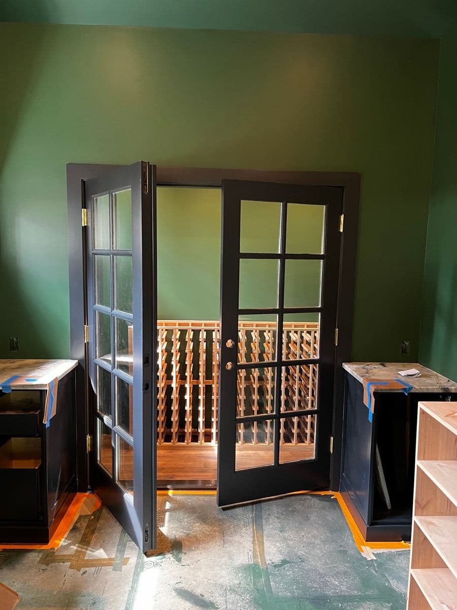 Wine cellar through the glass doors — racks being loaded with bottles